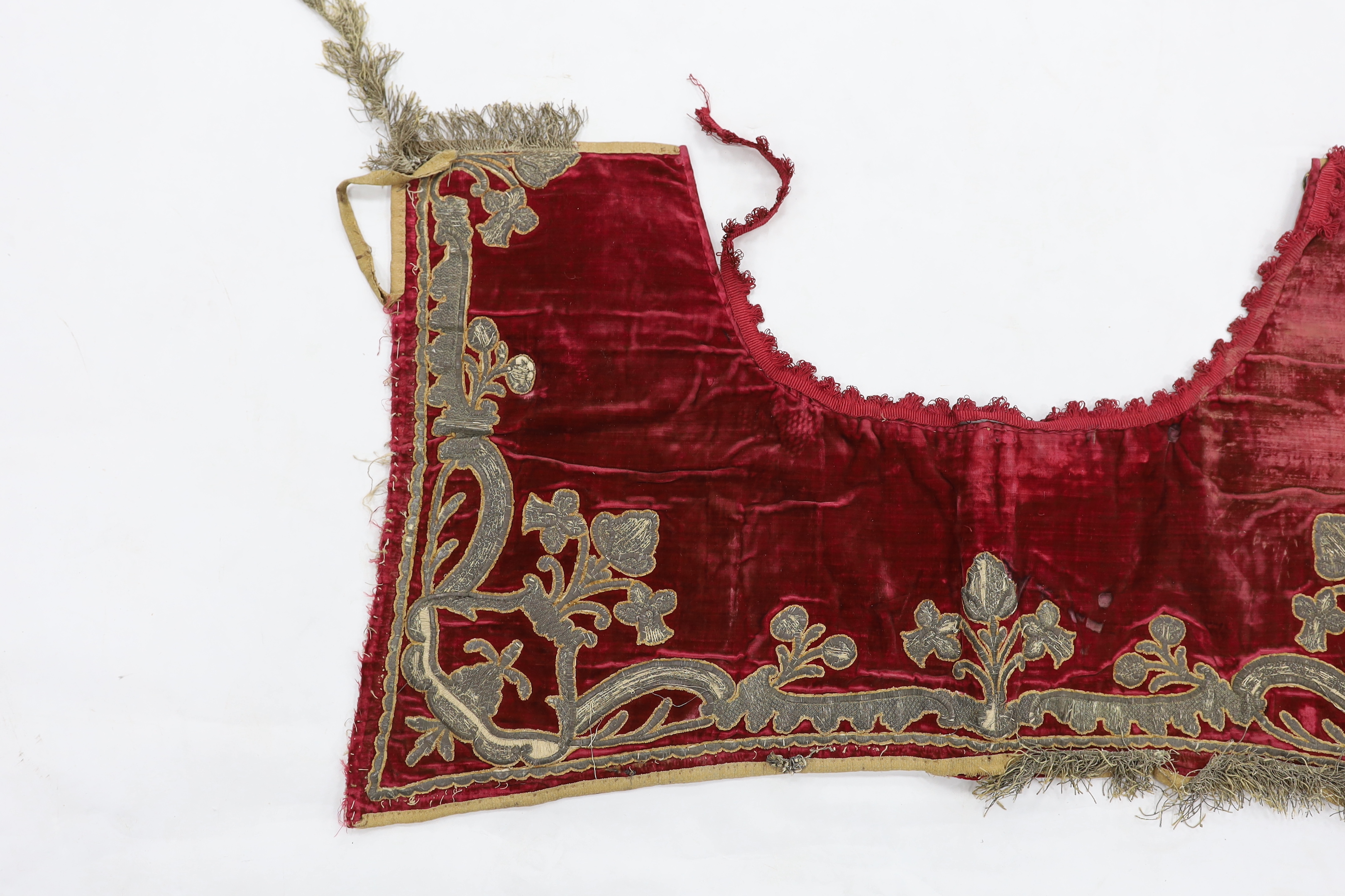 A burgundy velvet and silver thread embroidered and fringed saddle blanket, possibly Italian or Spanish, circa late 18th century, 94cm long x 50cm deep
